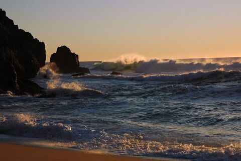 Waves breaking on rocks at sunset